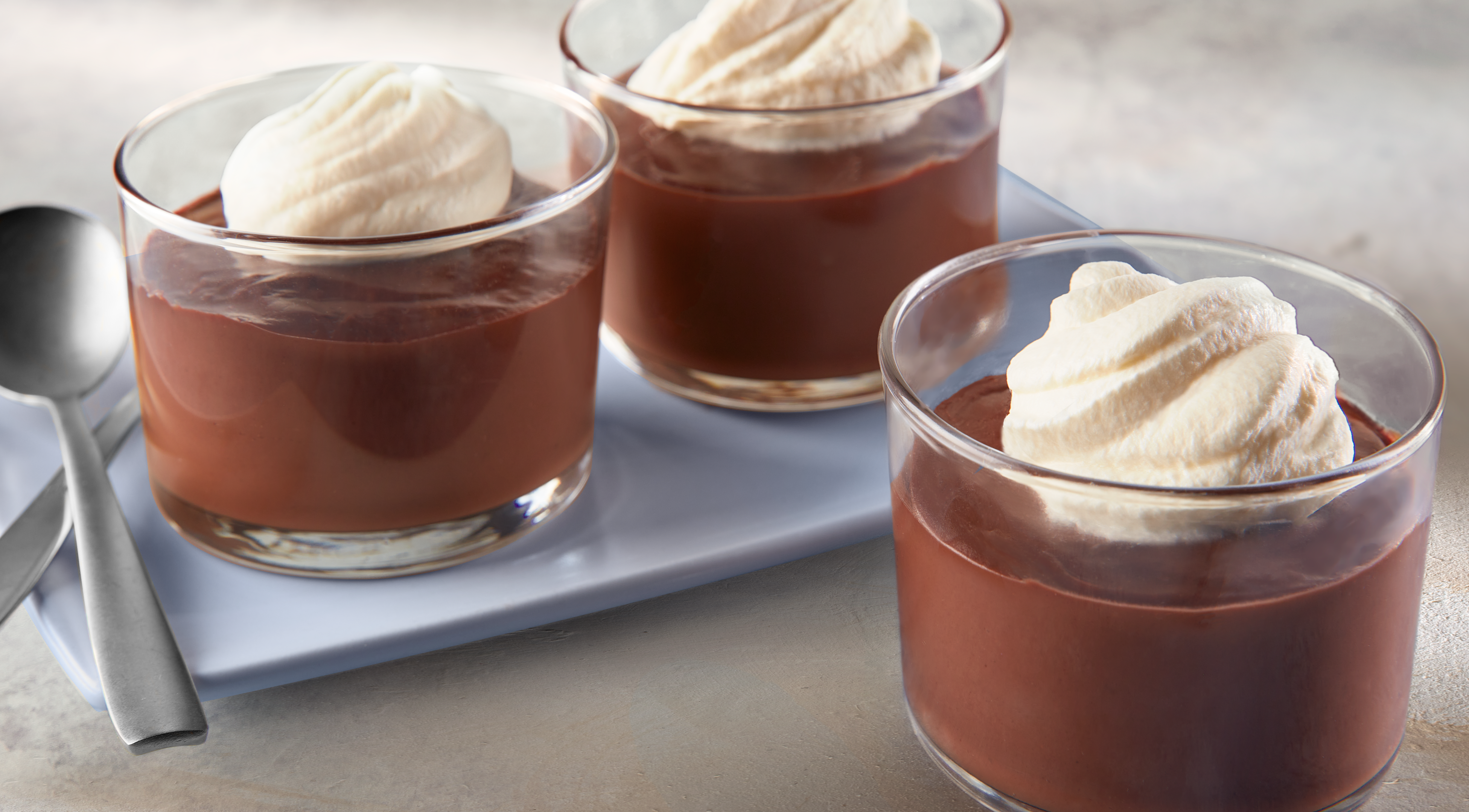 Chocolate Milk is poured into a glass cup on transparent